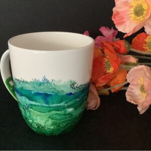 Photo of coffee or tea mug created using alcohol inks in ocean colours. Created by Ellen at Made in Lismore.